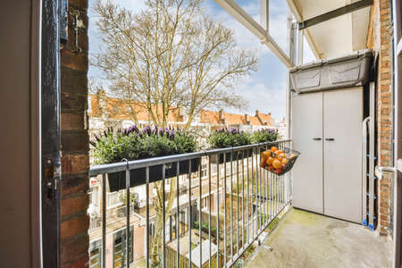 Narrow brick balcony with metal railings and door