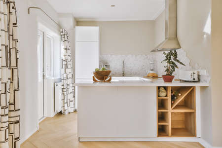 Interior of spacious light kitchen with modern white furniture and pop art portrait in light apartmentの写真素材