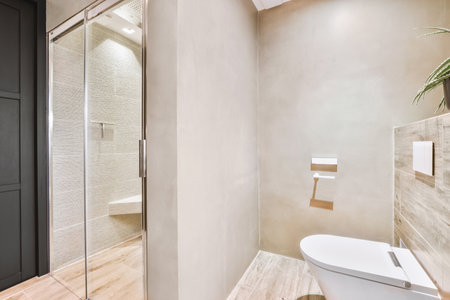 Sink base cabinet and mirror cabinet in white tiled bathroom with wall hung toiletの写真素材