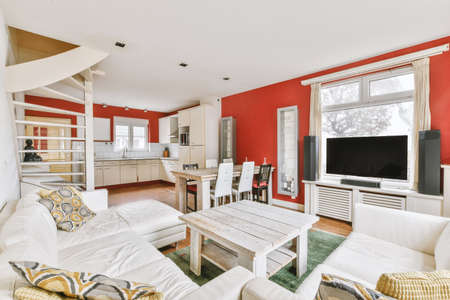 Cozy interior design of living room furnished with comfortable couch and wooden table decorated with...