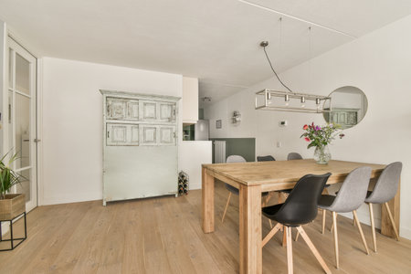 Contemporary minimalist style interior design of light studio apartment with wooden table and chairs...