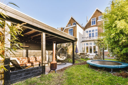Neat paved patio with sitting area and small garden near wooden fence