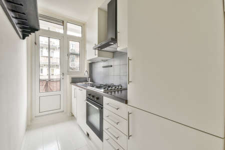 Interior of empty white kitchen with corridor and wooden parquet floor