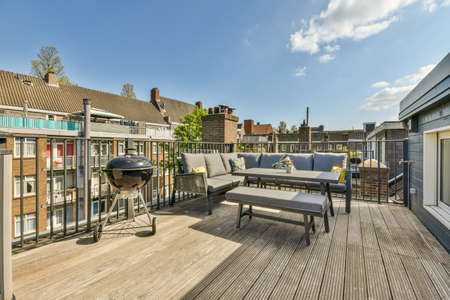 Bright wooden balcony with metal railings, wooden chair and door