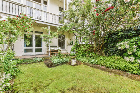 Neat paved patio with sitting area and small garden near wooden fenceの写真素材