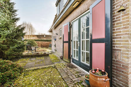 Neat patio with sNeat paved patio with sitting area and small garden near wooden fenceitting area