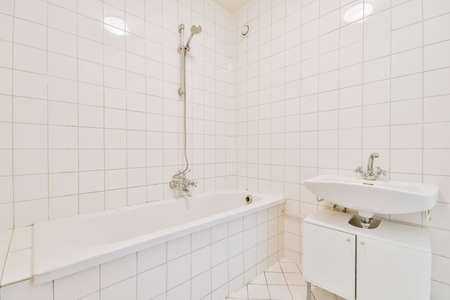 Sinks with mirrors and clean bathtub in modern bathroom with white tiled wallsの写真素材