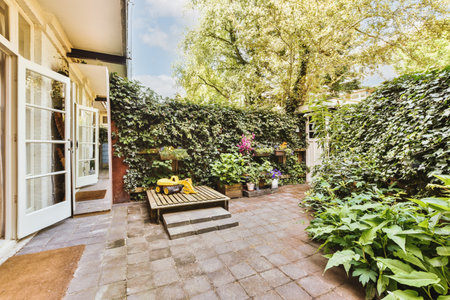 Neat paved patio with sitting area and small garden near wooden fenceの写真素材