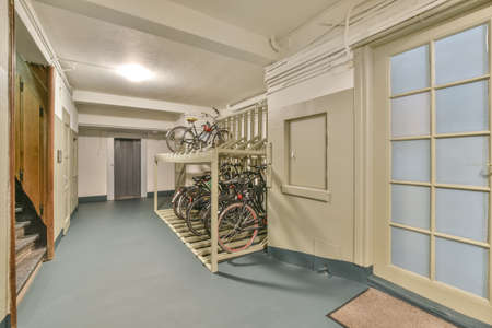 Corridor of contemporary apartment with black closets and opened doorway leading to terrace