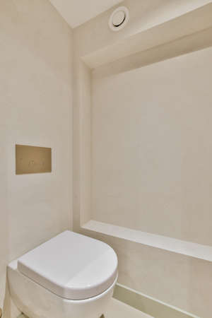 Interior of contemporary bathroom with shabby beige walls and partitions and white door at homeの写真素材