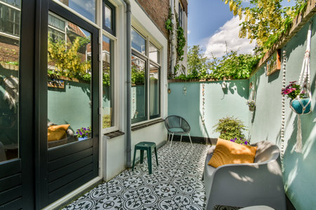 Neat paved patio with sitting area and small garden near wooden fence