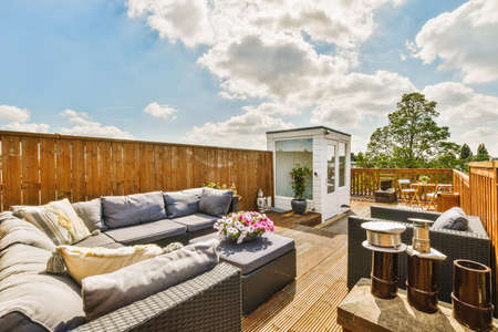 Bright wooden balcony with metal railings, wooden chair and door