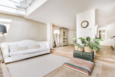 Comfortable sofas and wooden table placed near potted plants against window in living room of modern...