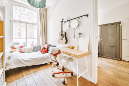 Home interior design of bedroom with bed and wooden wardrobe placed in corner near window in modern apartmentの写真素材
