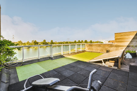 Neat paved patio with sitting area and small garden near wooden fenceの写真素材