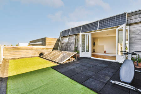 Neat paved patio with sitting area and small garden near wooden fence