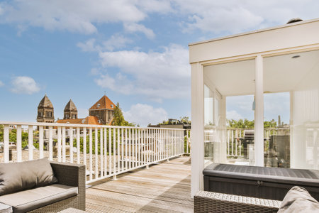 Bright brick balcony with metal railings, wooden chair and door with glass leads to the kitchenの写真素材
