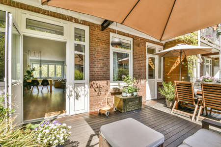 Neat powerful patio with sitting area and small garden near wooden fence