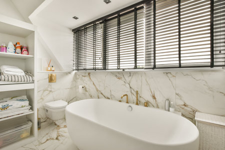 Shower and free-standing bathroom in light bathroom with washing machineの写真素材