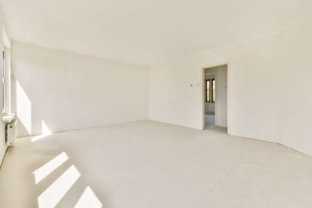 Plastic window and radiator on white wall in empty light room at home