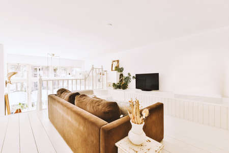 Interior design of modern minimalist style living room with large windows and wooden couch and...