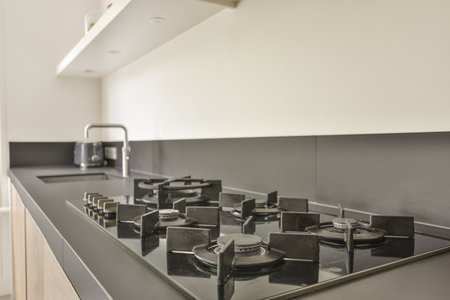 Table with chairs and flowers located near lounge area and kitchen in spacious room of contemporary apartmentの写真素材