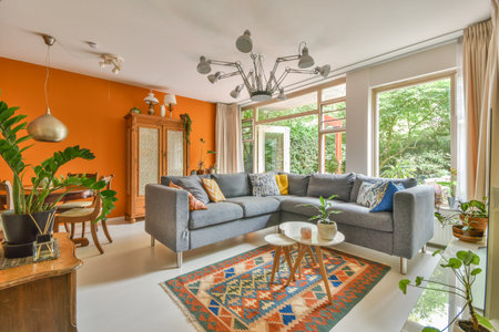 Cozy interior design of living room furnished with comfortable couch and wooden table decorated with carpet and lamp in modern apartmentの写真素材