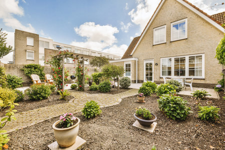 Neat paved patio with sitting area and small garden near wooden fence