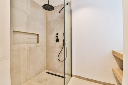Sinks with mirrors and shower box with glass door in modern bathroom with white tiled walls
