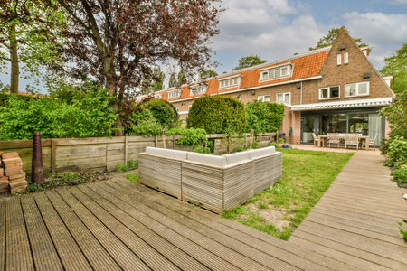 Neat powerful patio with sitting area and small garden near wooden fence