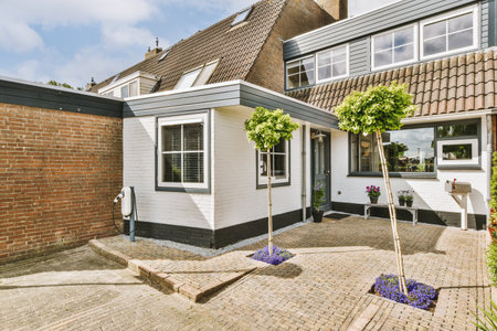Panorama view of brick houses from an empty sidewalk street with cars, trees and lanternsの写真素材