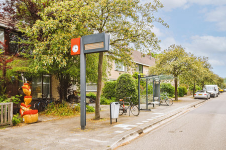 Panorama view of brick houses from an empty sidewalk street with cars, trees and lanternsの写真素材