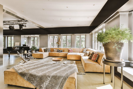 Stylish home interior design of spacious living room with large windows and white walls furnished with comfy couch and table on carpet on parquet floorの写真素材