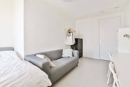 Home interior design of bedroom with bed and wooden wardrobe placed in corner near window in modern...