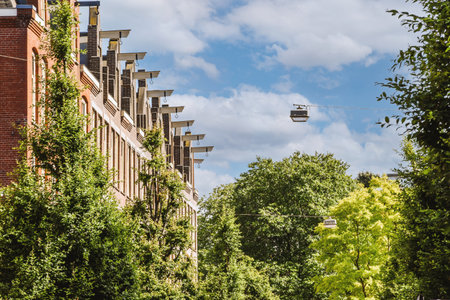 Panorama view of brick houses from an empty sidewalk street with cars, trees and lanternsの写真素材