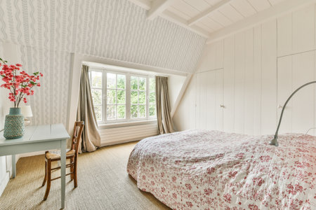 Pink bed placed near wall in modern minimalist style mansard bedroom with windows
