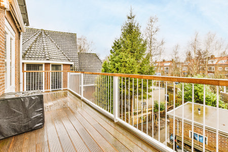 Brick balcony with metal railings, wooden chair and door with glass leads to the kitchen