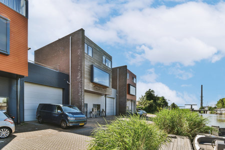 Panorama view of brick houses from an empty sidewalk street with cars, trees and lanterns
