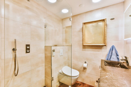 Flush toilet located between sink and shower in small tiled bathroom of contemporary apartment