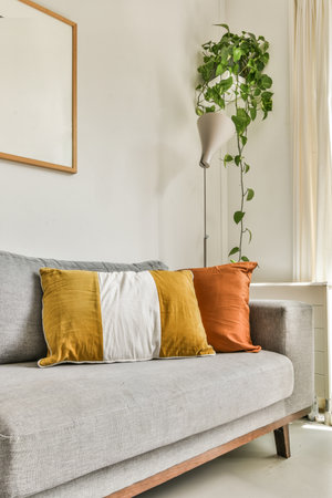 Table with chairs and flowers located near lounge area and kitchen in spacious room of contemporary apartmentの写真素材