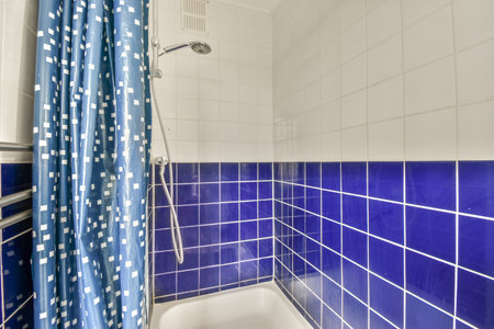 Cupboard with sink and mirror attached to tiled wall near door