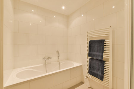 Sinks with mirrors and clean bathtub located near shower box with glass door in modern bathroom with white tiled wallsの写真素材