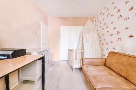 Interior of white room with baby crib and armchair near window with blue chest of drawers in daylightの写真素材