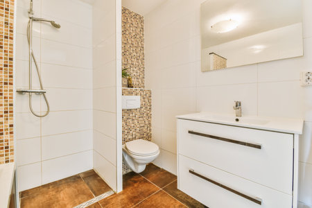 a bathroom with tiled walls and wood flooring on the wall, there is a white toilet next to the sink