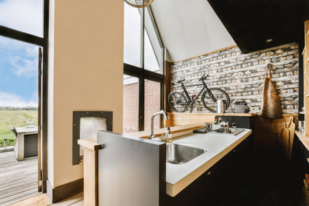 Fragment of interior of light narrow home kitchen with minimalist style furniture with sink and...