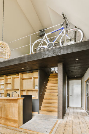 White hallway with wooden stairway leading to second floor of modern luxury apartment with...