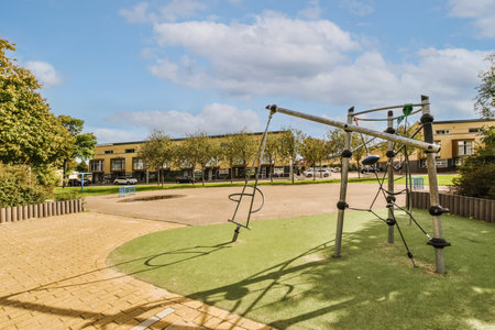 an outdoor playground area with swings, slides and climbing equipment on the ground in front of a...
