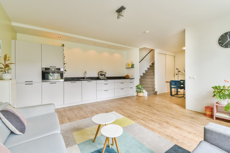 a living room with wood flooring and white cupboards on either side of the room, there is a large...