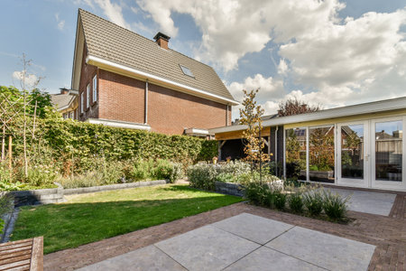 Neat powerful patio with sitting area and small garden near wooden fence