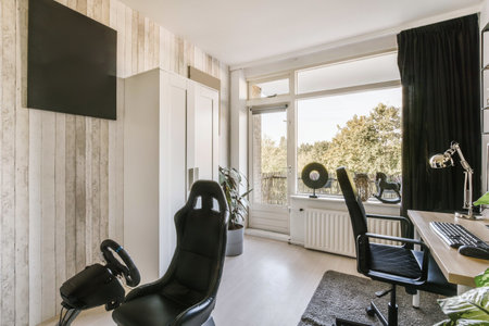 a room with a chair, desk and television on the wall in front of the tv is mounted to the wallの写真素材